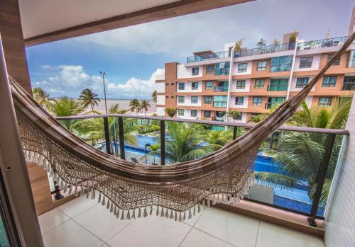 a hammock in a room with a view of a hotel at Luxor Paulo Miranda Home Service in João Pessoa