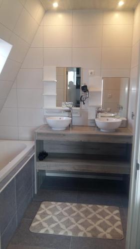a bathroom with two sinks and a tub and a mirror at Appartementen De Helling 44 in Heeg
