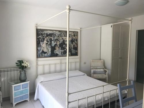 a bedroom with a canopy bed and a painting on the wall at Villa Messina in Capoliveri