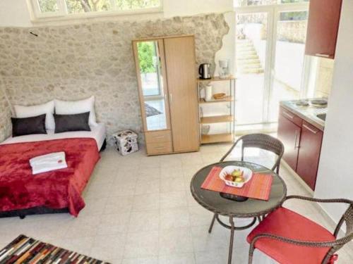 een slaapkamer met een bed en een tafel en een keuken bij Gartenapartment Villa Luger in Ražanj