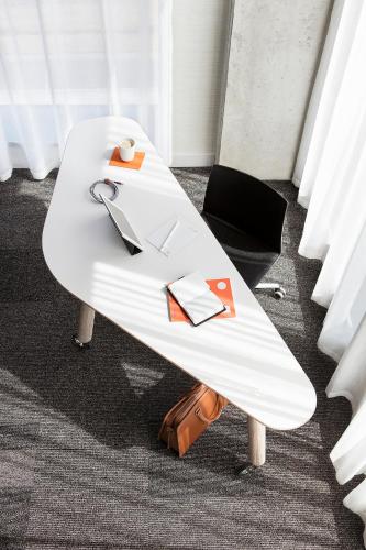 a white surfboard sitting on top of a table at Hôtel Escad Quartier DIX30 in Brossard