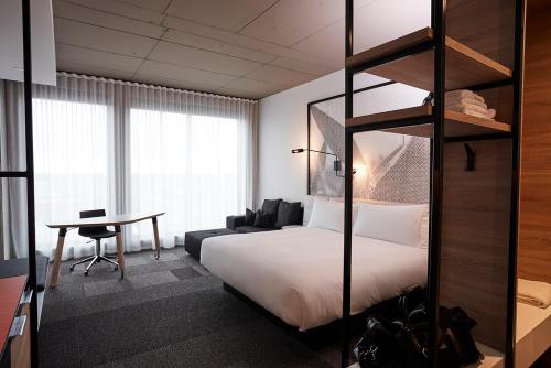 Pokój hotelowy z łóżkiem i biurkiem w obiekcie Hôtel Escad Quartier DIX30 w mieście Brossard