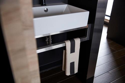 a bathroom sink with a towel hanging on a wall at Hôtel Escad Quartier DIX30 in Brossard