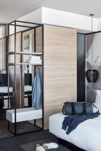 a bedroom with a bed and a mirror at Hôtel Escad Quartier DIX30 in Brossard
