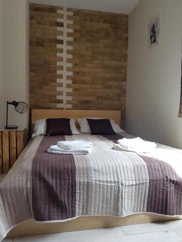 a bedroom with a large bed with blankets and pillows at Apartament Country Centrum in Gorzów Wielkopolski