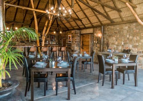 a dining room with tables and chairs in a building at Ikwanitsha Lodge in Paterson