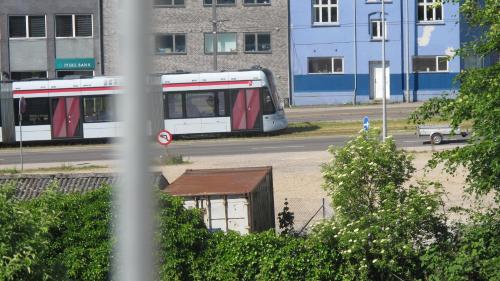 a train traveling down a street in a city at Guesthouse Sharon Aarhus in Aarhus