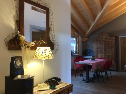 una camera con tavolo, specchio e lampada di b&b Casa Tavernaro a Fiera di Primiero