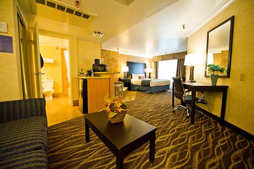 une chambre d'hôtel avec un salon doté d'un canapé et d'une table dans l'établissement Hotel d'Lins Ontario Airport, à Ontario