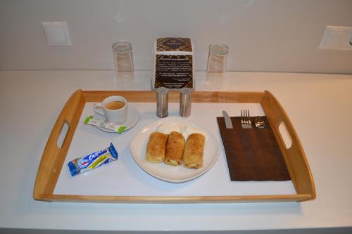 a tray with a plate of pastries and a cup of coffee at Sherton Hotel in Rostov on Don