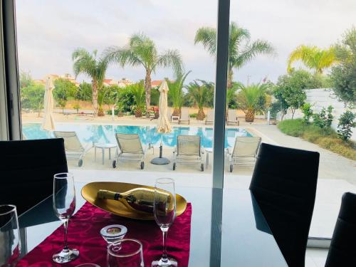 a table with wine glasses on a table with a view of a pool at Royal Sugar in Ayia Napa