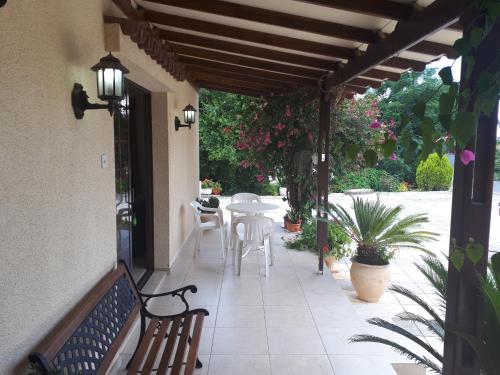 a patio with a bench and a table and chairs at Droushia Holiday Apartments in Drousha