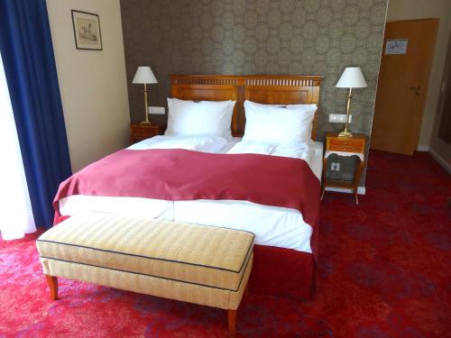 a hotel room with two beds with red carpet at Hotel Erbprinzenpalais in Wernigerode
