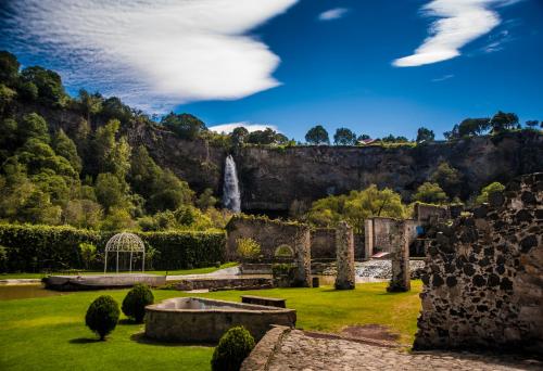 a view of the ruins of a castle with a waterfall at Hacienda Santa Maria Regla in Huasca de Ocampo
