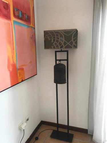 een lamp in een hoek van een kamer met schilderijen bij Seaside doors in Vila Real de Santo António
