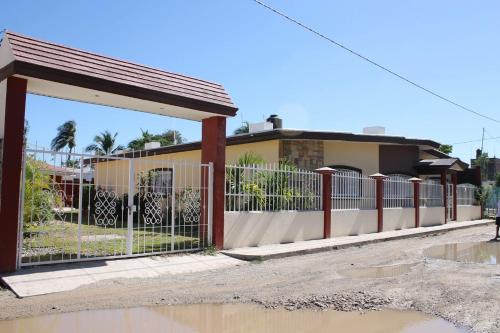 a fence in front of a house with water on the ground at Melaque Paradise in San Patricio Melaque