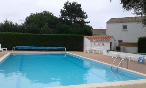 une grande piscine bleue dans une cour dans l'établissement les genets, à Bretignolles-sur-Mer
