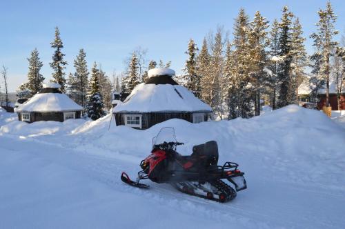 a snowmobile parked in the snow in front of domes at Camp Alta Kiruna in Kiruna
