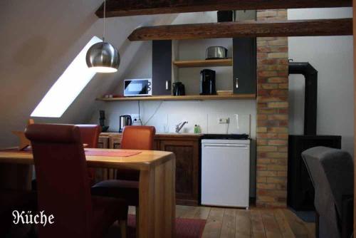 a kitchen with a table and a white refrigerator at Rugia 2 in Stralsund