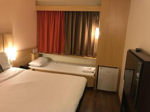 a hotel room with two beds and a window at ibis Sao Paulo Morumbi in Sao Paulo