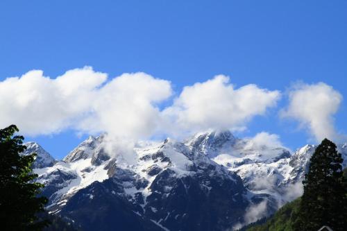 a snow covered mountain with clouds in the sky at Hôtel Panoramic in Luchon