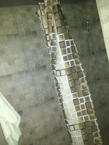 a shower with a tiled wall and a glass showeroser at Graffiti Mega City in Kyiv