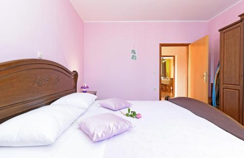sypialnia z łóżkiem z białymi prześcieradłami i poduszkami w obiekcie Apartment Dvori with pool w mieście Kaštelir