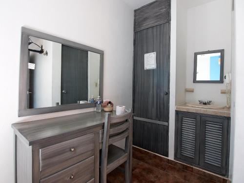 a bathroom with a vanity with a mirror and a sink at Hotel Tabasco Rio in Río Lagartos