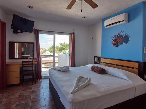 a bedroom with a bed with a blue wall at Hotel Tabasco Rio in Río Lagartos