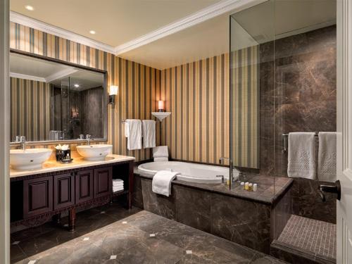 a bathroom with a sink, toilet and bathtub at Oak Bay Beach Hotel in Victoria