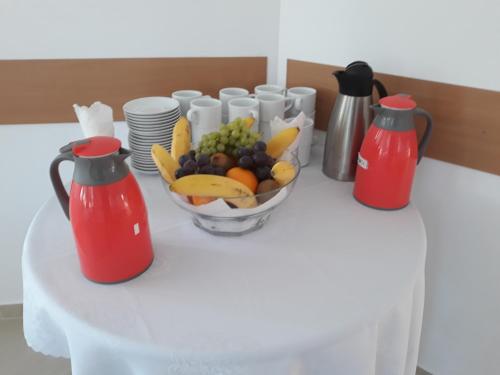 stół z miską owoców i dwoma czajnikiem w obiekcie Biesiadny Dworek w mieście Szpegawa