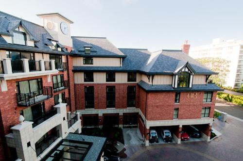 an apartment building with a clock on top of it at Oak Bay Beach Hotel in Victoria