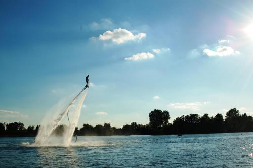 a person is standing on a board in the water at Osada Kryspinów in Cholerzyn