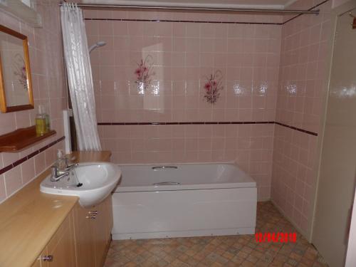 a bathroom with a sink and a bath tub and a sink at Glen Croft Cottage in Invermoriston