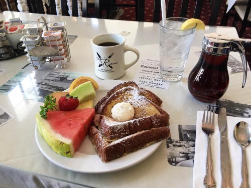 a plate of bread and fruit on a table with a cup of coffee at Boulder Dam Hotel in Boulder City