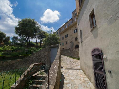 a building with a gate next to a stone wall at Apartment La Fonte by Interhome in Volterra