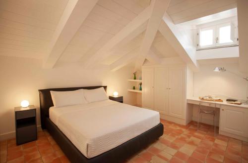 a bedroom with a bed and a desk with two lights at Tenuta Duca Marigliano Boutique Hotel in Paestum