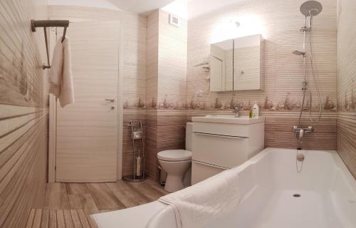 a bathroom with a tub and a toilet and a sink at Apartament Ana Navodari Mamaia Nord in Mamaia Nord