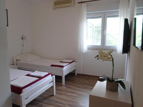 Habitación pequeña con 2 camas y ventana en Apartments Marin Tomas, en Dubrovnik