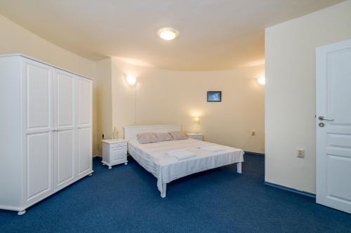 a bedroom with a bed and two white cabinets at Villa White Dove in Golden Sands