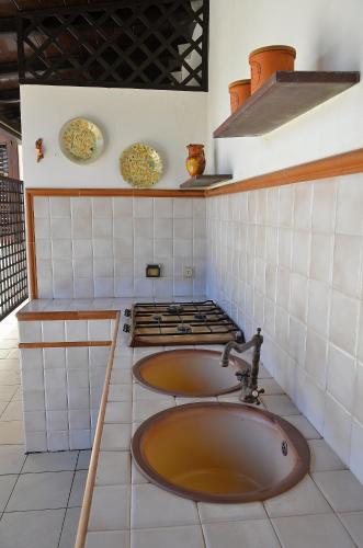 a kitchen with a sink and a stove with plates at Guest House Adele in Marina di Ragusa