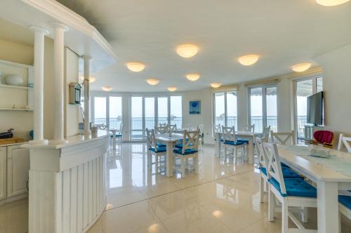 uma sala de jantar com mesas, cadeiras e janelas em Villa White Dove em Golden Sands