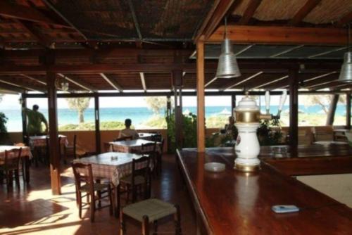 a restaurant with tables and chairs and a view of the ocean at Mousses Apartments & Studios in Kissamos
