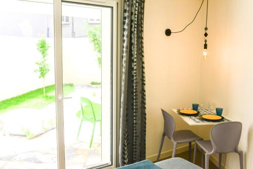 une salle à manger avec une table et une porte en verre dans l'établissement Studio les Hortensias, à Avignon