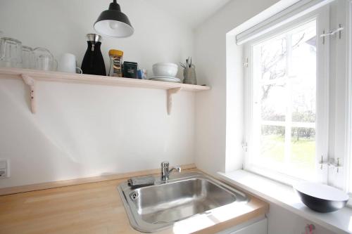 cocina con fregadero y ventana en Cozy Guesthouse, en Gilleleje