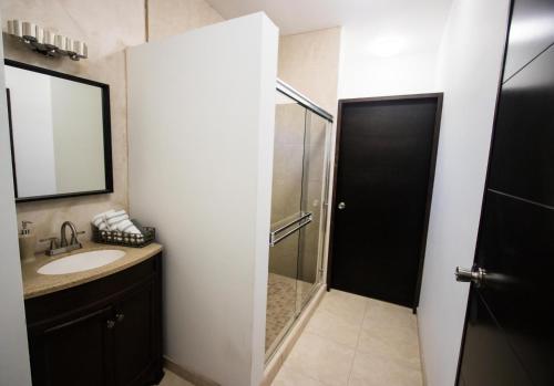 a bathroom with a shower and a sink and a mirror at Cuatro Lunas Hotel Boutique in Valle de Guadalupe
