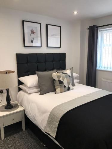 a bedroom with a large bed with a black headboard at Coleman Studios in Wolverhampton