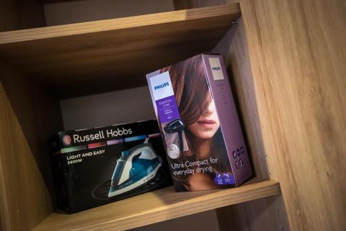 a book shelf with two dvds and two books at Mokka Apartman Szeged in Szeged