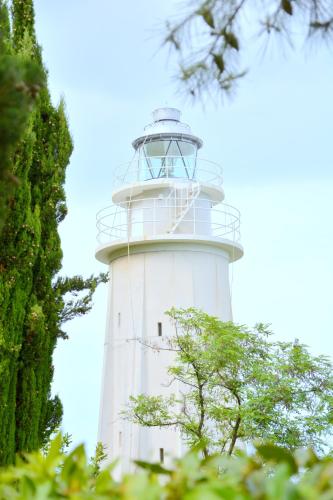 a white lighthouse with trees in front of it at Hotel Cormorano in Pedaso