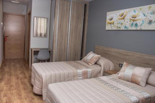 Habitación de hotel con 2 camas y sofá en O Vendaval Hostal Restaurante en Barreiros